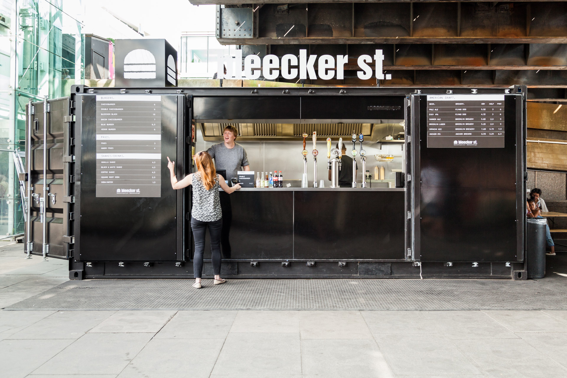 WOMAN ORDERING BURGER AT BLACK AND WHITE STREET FOOD CONTAINER