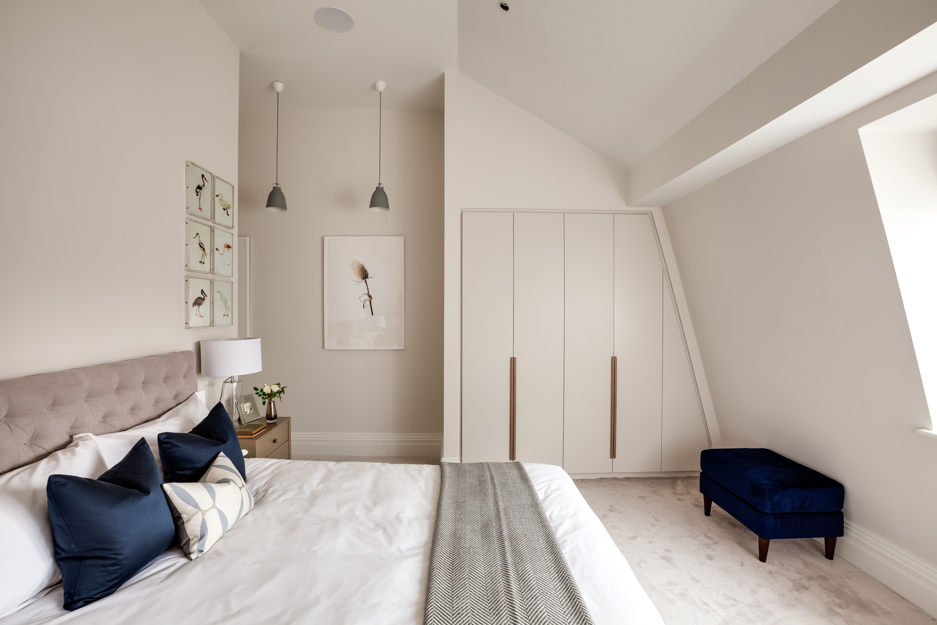 Custom modern wardrobe design in neutral guest bedroom in eaves.