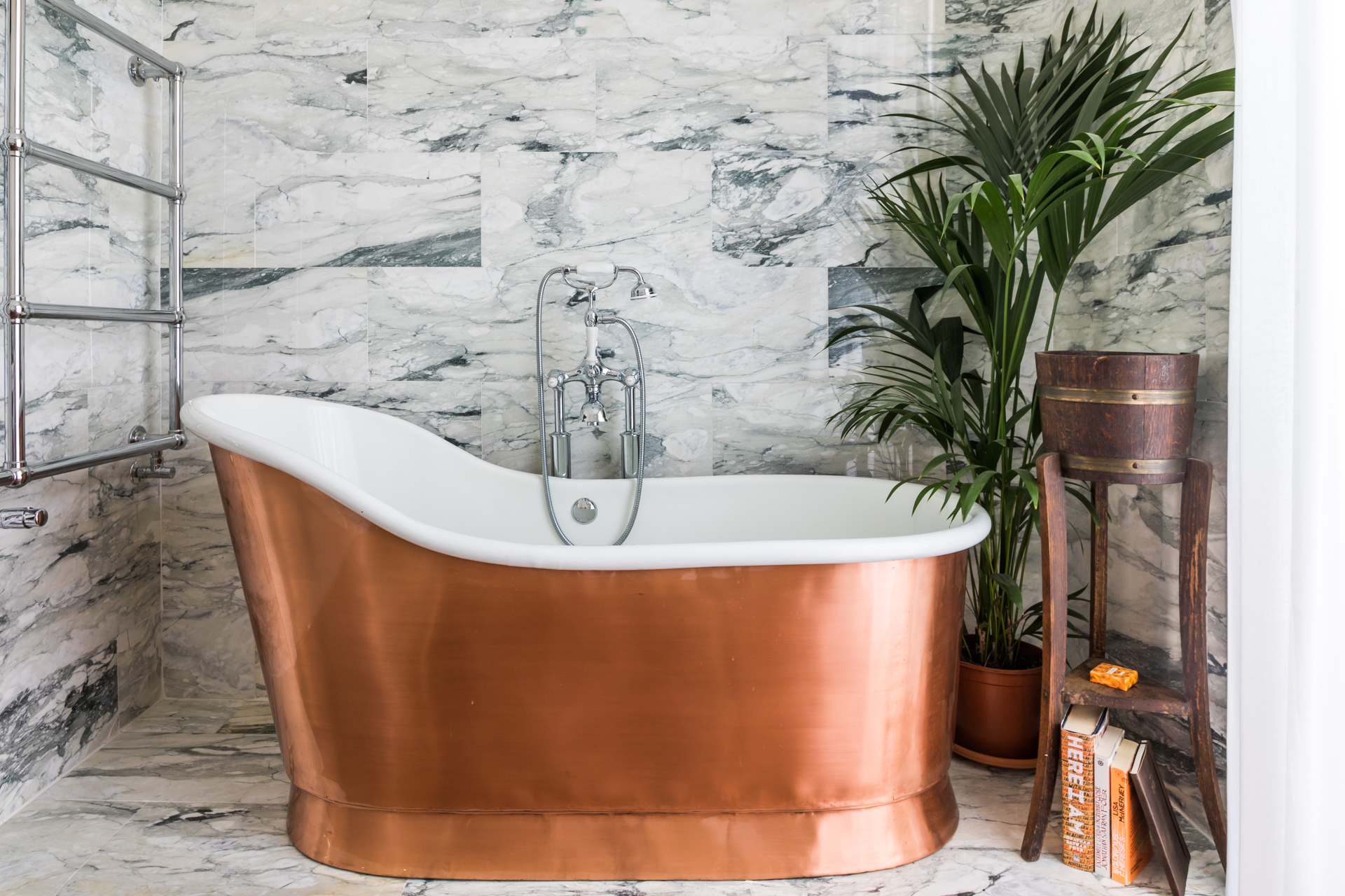 copper plated cast iron traditional bath with veined marble tile