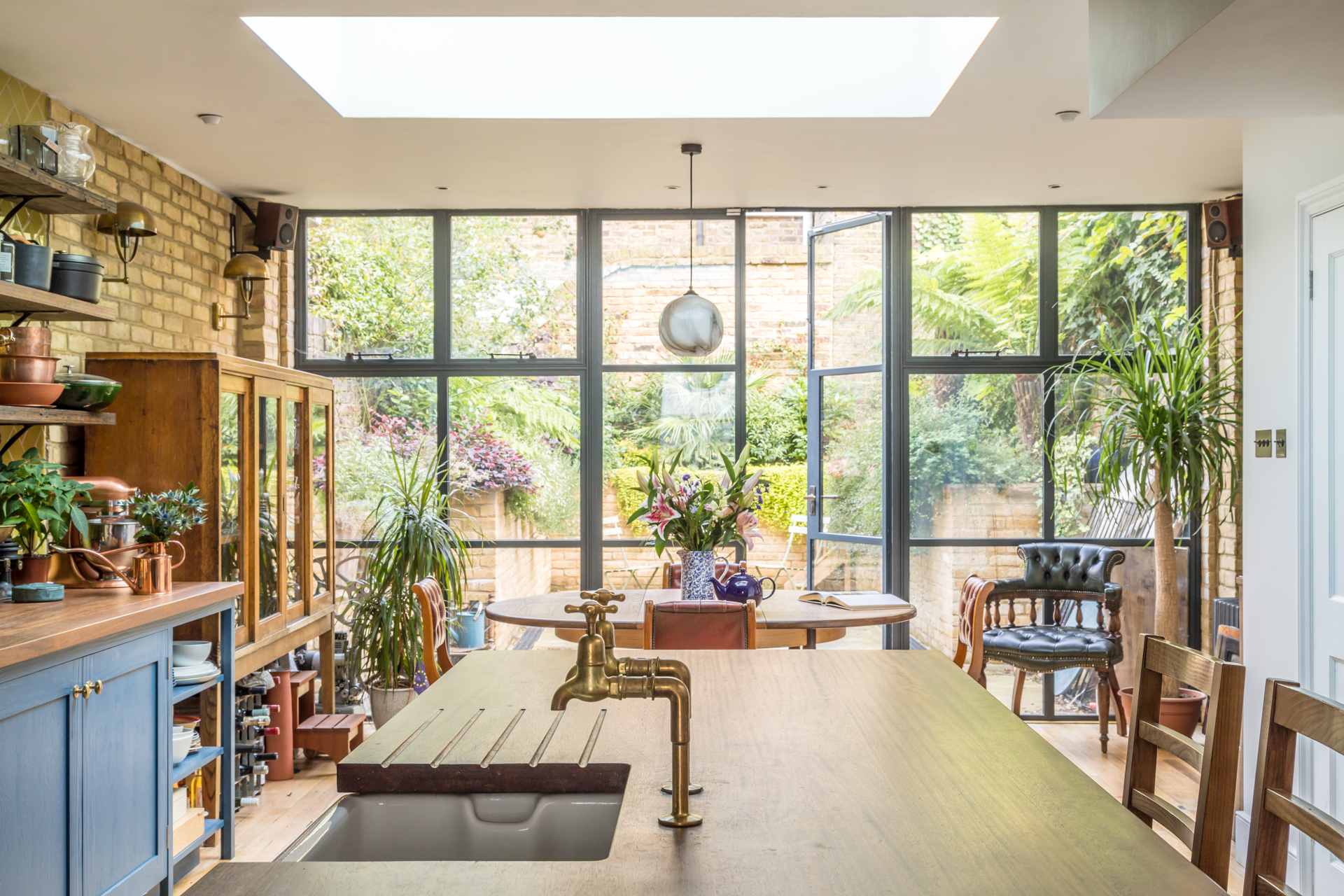 Traditional blue shaker kitchen open plan onto garden